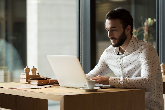 Side view business man working on laptop