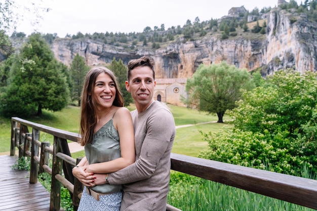 Side view of caucasian couple in love traveling in countryside. Horizontal view of young couple sightseeing in the river Lobos canyon. People traveling in spanish travel destinations.