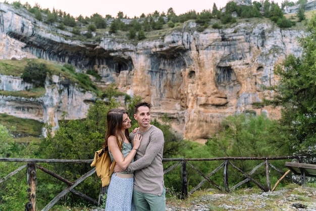 Side view of caucasian couple in love traveling in countryside. Horizontal view of young couple sightseeing in the river Lobos canyon. People traveling in spanish travel destinations.