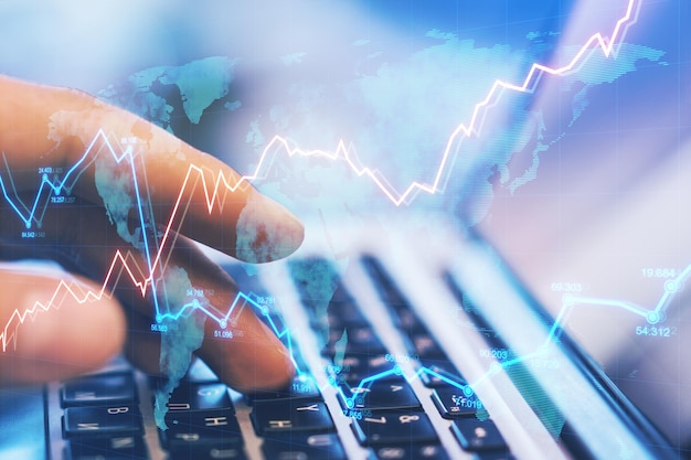 Side view and close up of hands using laptop on desktop with abstract forex chart Fintech trade and data exchange concept Double exposure