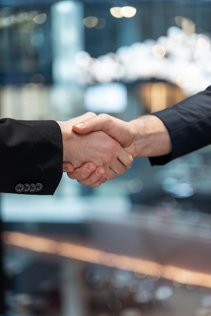 Side view colleagues shaking hands at work