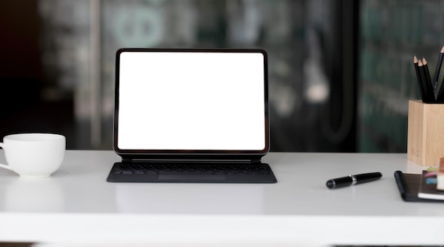 Side view of contemporary workplace with laptop computer notebook coffee cup and stationery on wooden tablexA