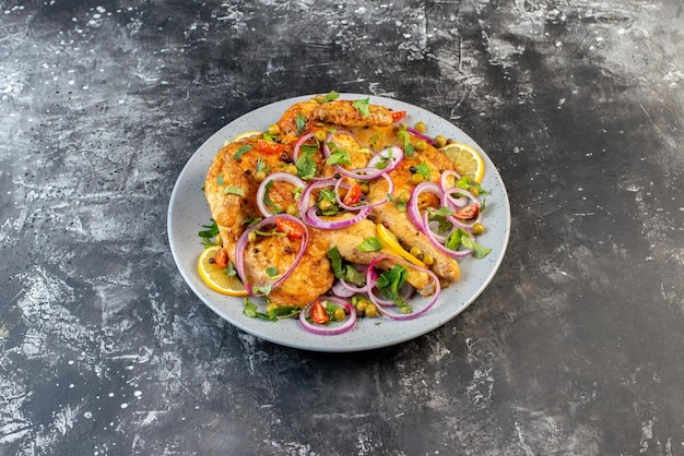 Side view of delicious dinner fried chicken dish with various spices and foods on dark color background