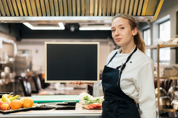 Side view of female chef posing in the kitchen