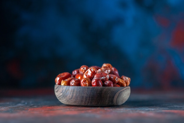 Side view of fresh raw silverberry fruits in bowl on mix colors background with free space