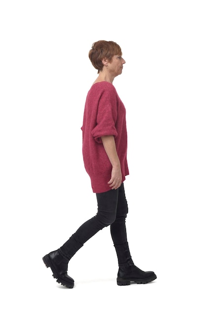 Side view of a full length portrait of woman walking in tight jean pants on white background