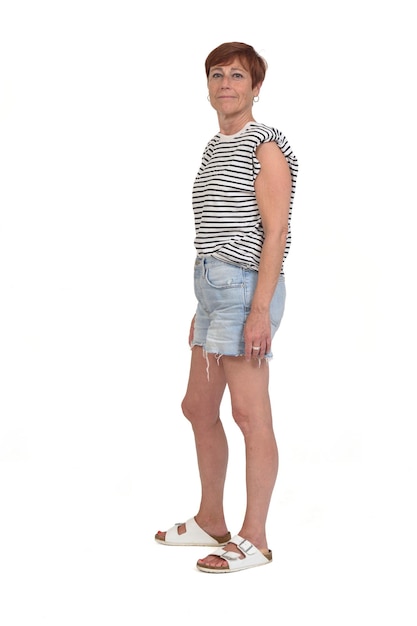 Side view of a full portrait of a middle aged woman looking at camera on white background