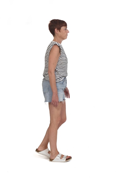 Side view of a full portrait of a middle aged woman walking on white background