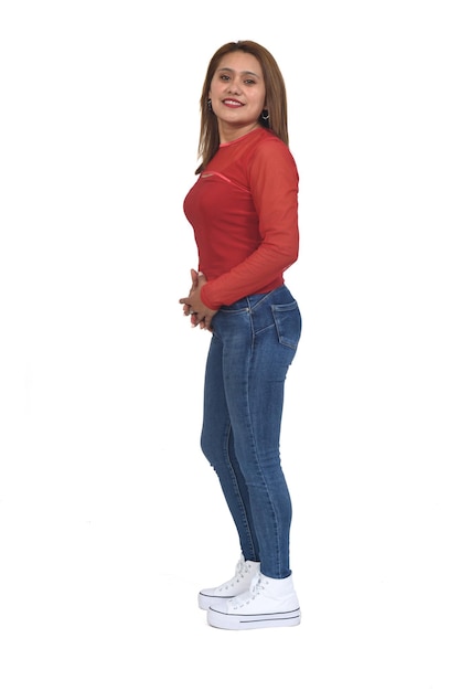 Side view of a full portrait of a women with jeans and sneaker looking at camera white background