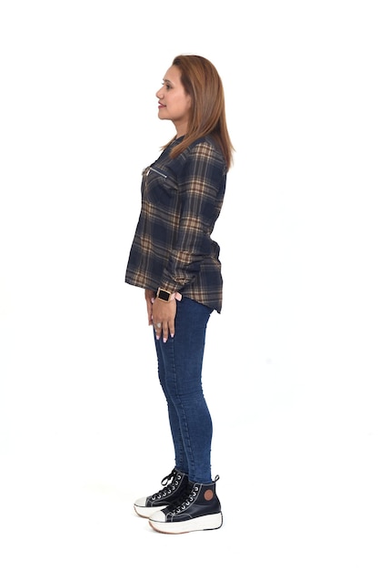 Side view of a full portrait of a women with jeans and sneaker white background