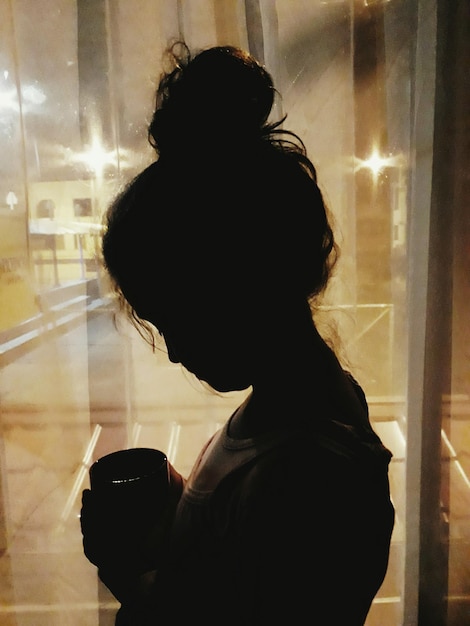 Photo side view of girl holding mug indoors