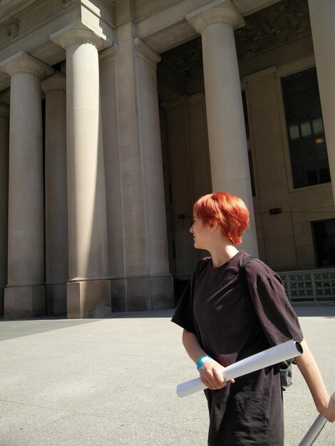 Photo side view of girl teenager walking by building in city