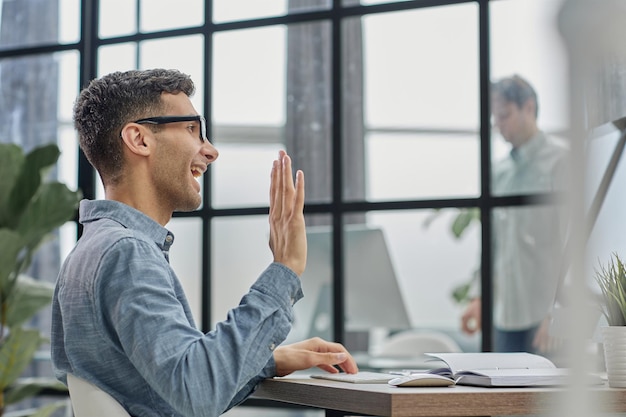 Side view of handsome young businessman looking at computer