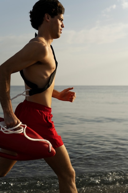 Side view lifeguard running on beach