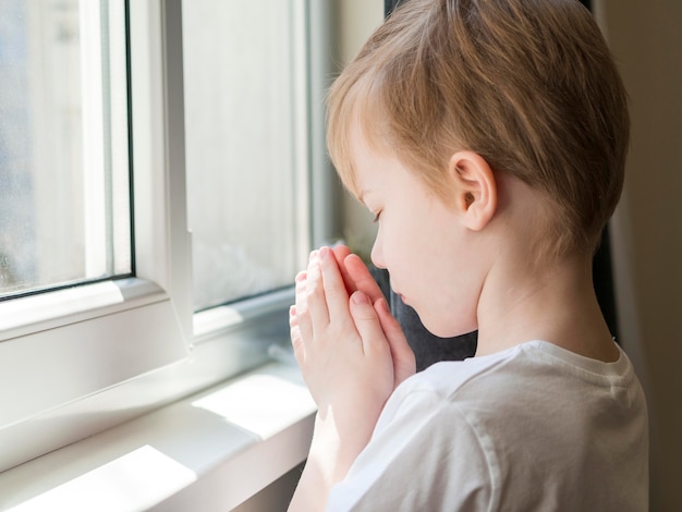 Side view of little boy praying