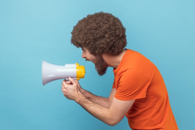 Side view of man loudly screaming at megaphone making announce protesting wants to be heard