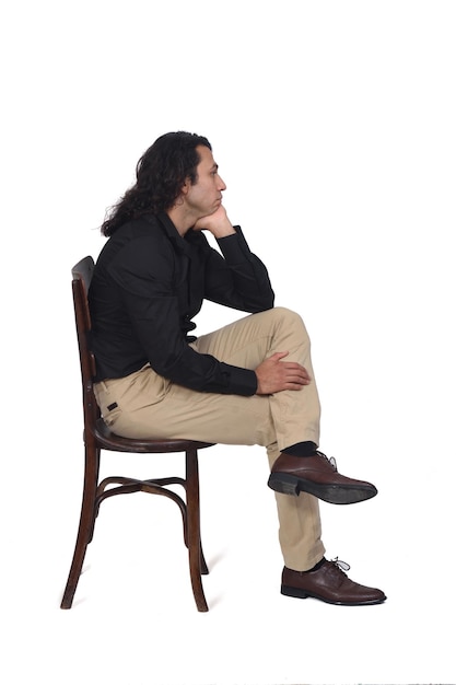 Side view of a man with shirt, shoes and pants  sitting on chair  on white background