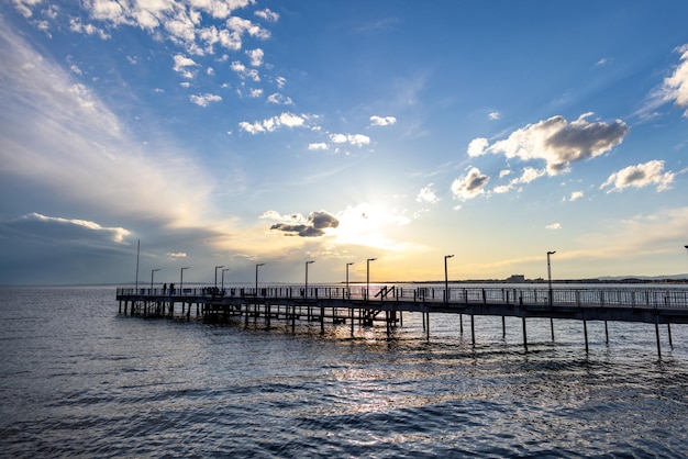 Side view of the pier on the Black Sea against the background of the sky and sunset