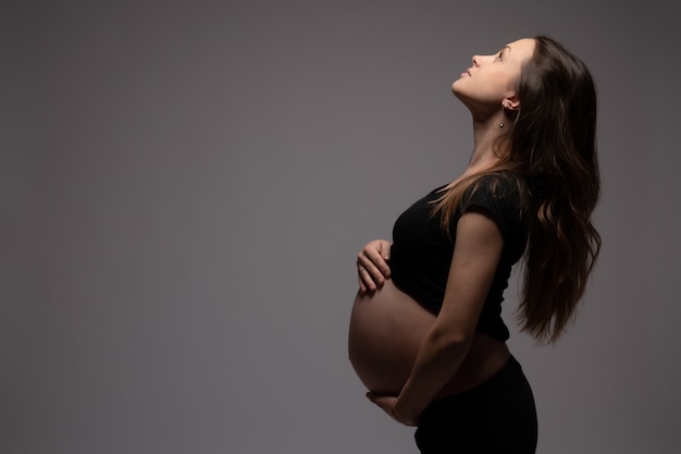 Side view portrait of the beautiful pregnant woman