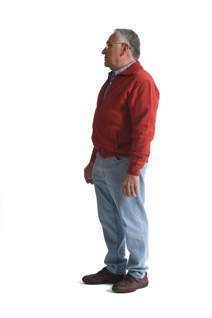 Side view of a senior man standing and looking away on white background