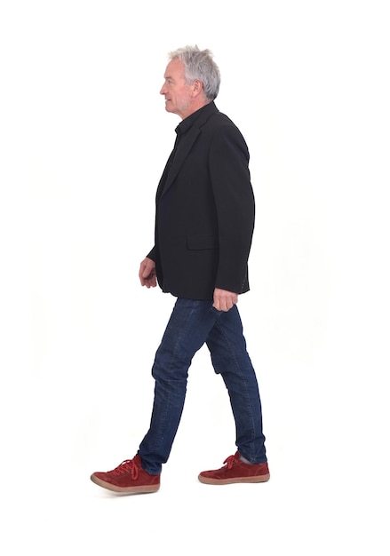 Side view of senior man walking on white background