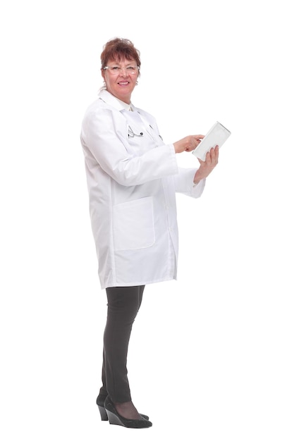 Side view of senior woman doctor with stethoscope write on tablet looking at camera