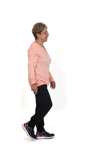 Side view of senior woman walking on white background