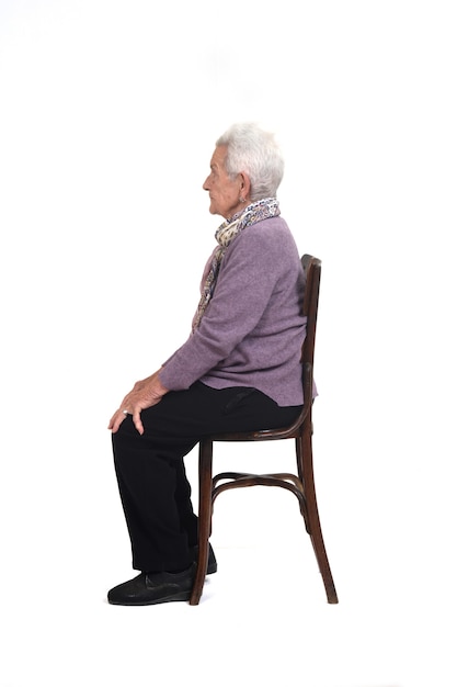 Side view of a senir woman sitting on chair on white background