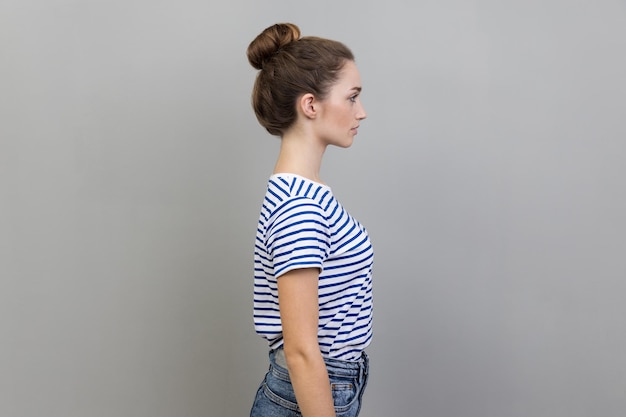 Side view of serious bossy woman standing looking ahead with strict facial expression