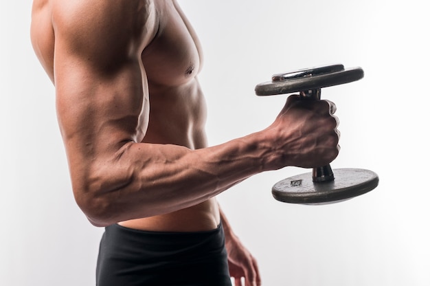 Side view of shirtless athletic man torso holding weights