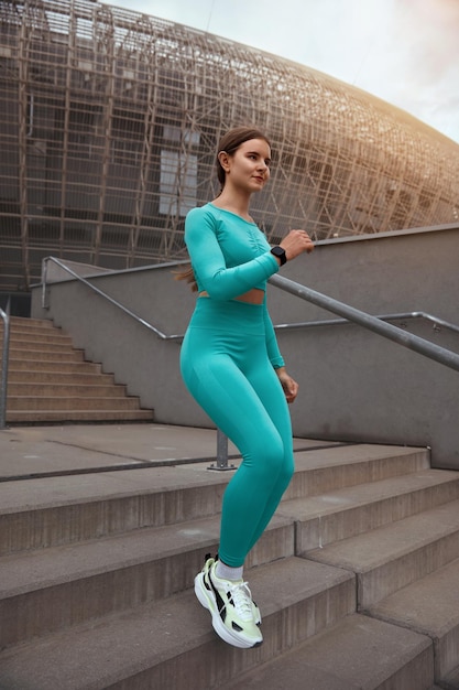 Side view shot of fitness woman running on steps Female runner athlete going down stairs