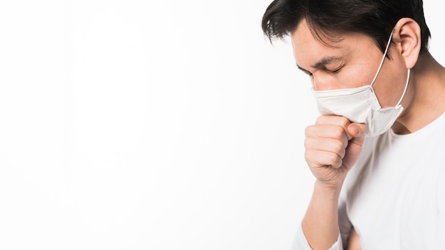 Side view of sick man with medical mask coughing