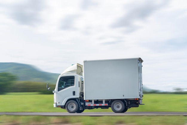 Side view of a small truck driving on a country road truck running on the road small truck on the road