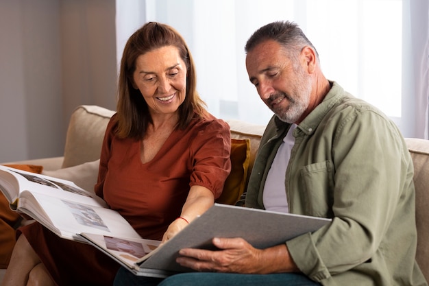 Side view smiley couple looking at picture album