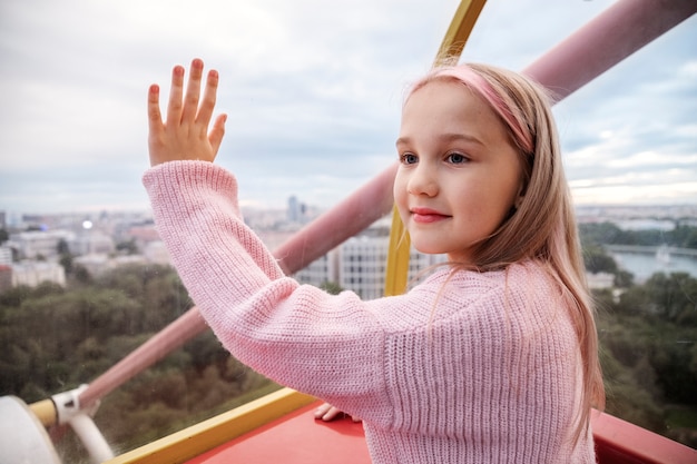 Side view smiley girl on the ferris wheel