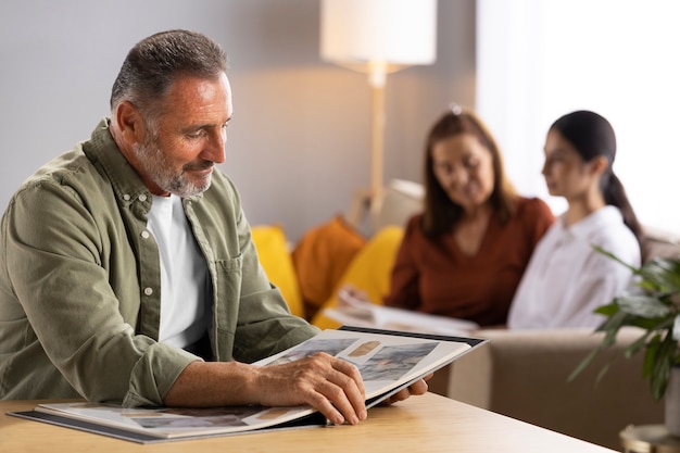 Side view smiley man looking at picture album