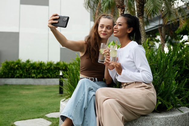 Side view smiley women taking selfie