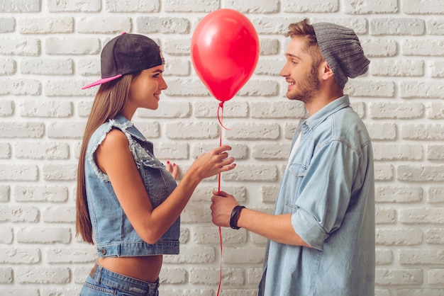 Side view of stylish teenage couple in jean clothes.