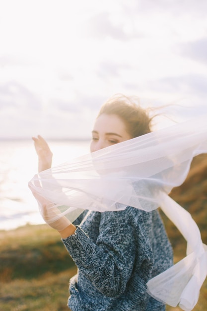 Photo side view of teenage girl holding scarf at beach