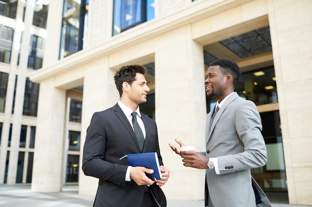 Side view of two businessmen having work discussion outdoors