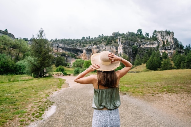 Side view of unrecognizable woman walking isolated in nature. Horizontal view of woman traveling alone in the Lobos river canyon in Soria. People and travel destinations in Spain.