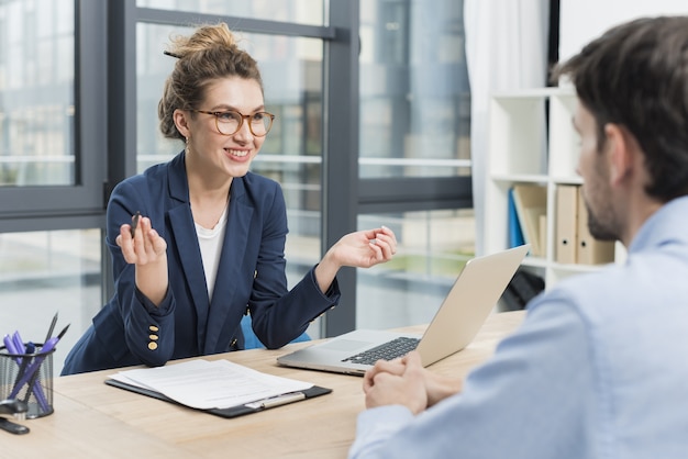 Side view of woman holding a job interview with man