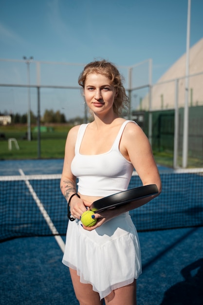 Side view woman holding tennis paddle