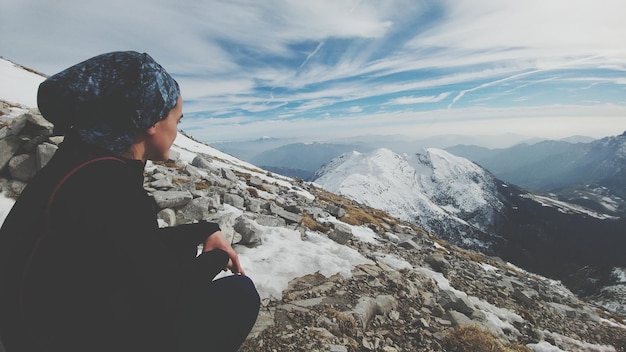 Side view of woman on mountain landscape against sky