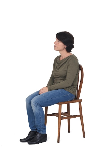 Side view woman sitting on a chair looking away on white background