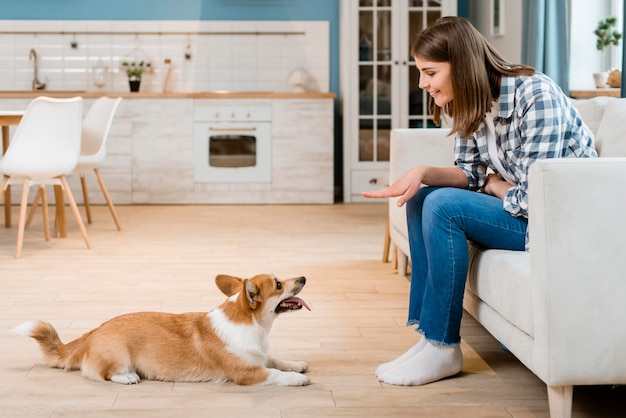 Side view of woman telling her dog to sit