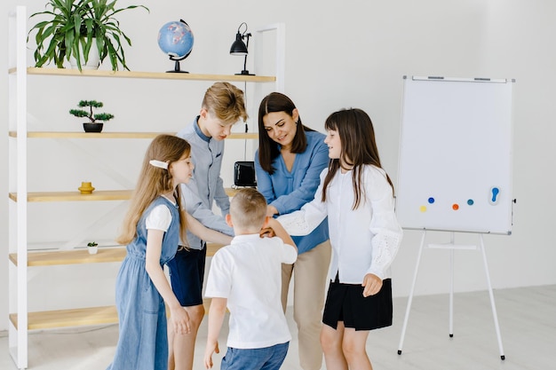 Side view Woman with his kids students in holding hands for success