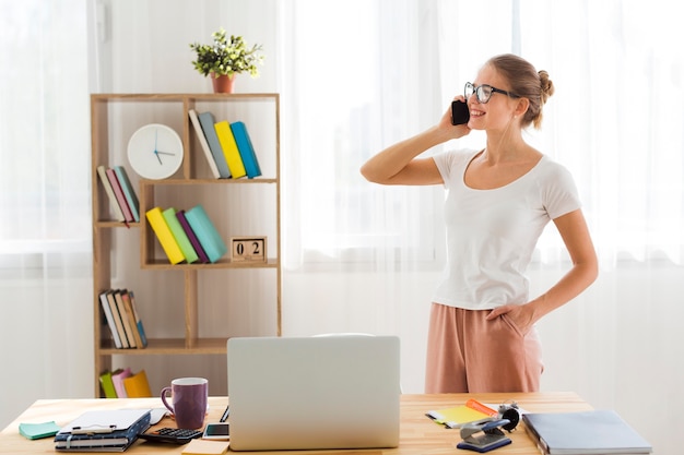 Side view of woman working from home and talking on phone