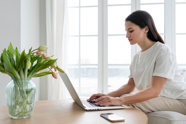 Side view woman working on laptop