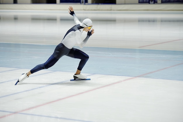 Side view of young active man having speed skating training